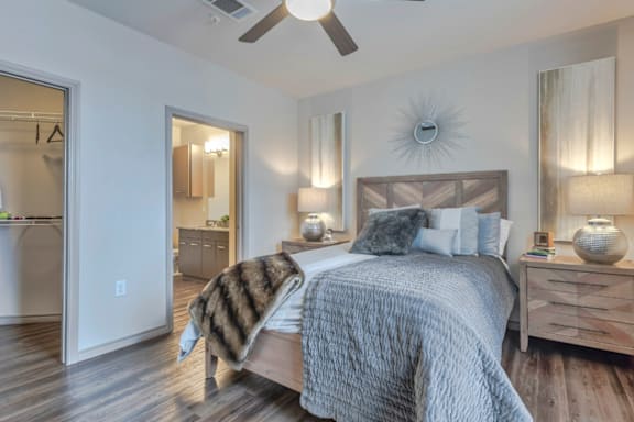 A bedroom with a bed, nightstands, and a ceiling fan.
