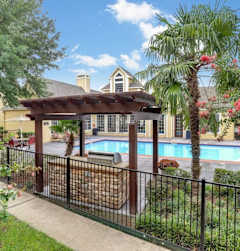 A pool area with a black fence and a gazebo.