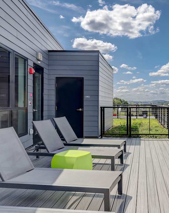 A balcony with a table and chairs overlooking a cityscape.