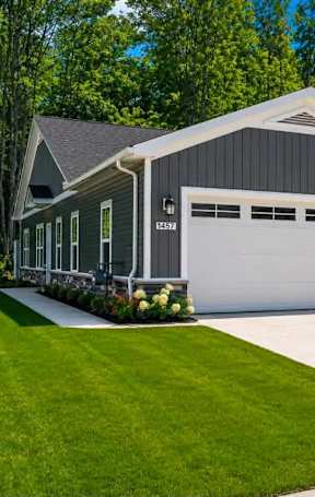 A house with two garages and a well-maintained lawn.