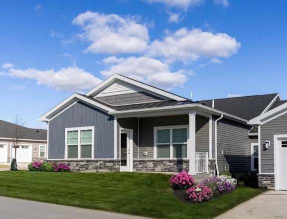 A grey house with a white garage door and windows.