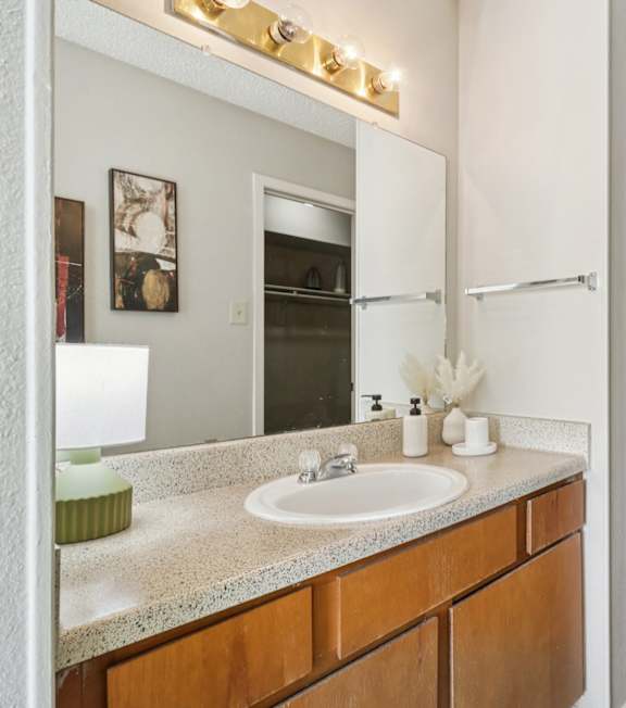 A bathroom with a sink, mirror, and a white door.