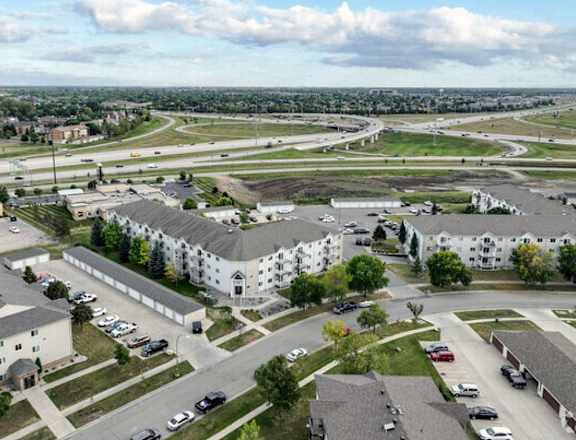 an aerial view of an apartment community with cars parked on the street