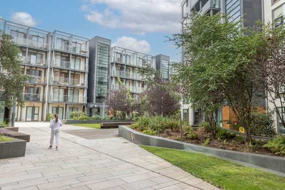 a woman walking on a sidewalk in front of buildings