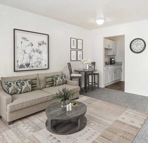 Spacious living room and kitchen with white cabinets at Newport Village Apartments, Portage, Michigan
