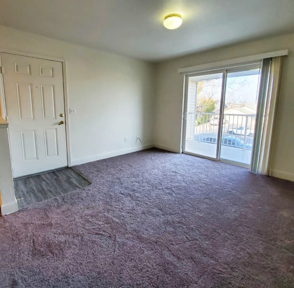Image of living space with glass sliding door opening to balcony