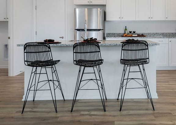 Two black barstools are in front of a kitchen island.