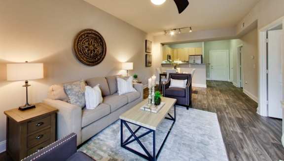 A living room with a couch, a coffee table, and a ceiling fan.