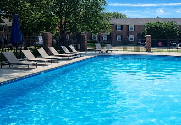 A large blue swimming pool surrounded by a black fence.