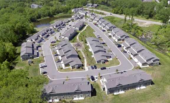 A bird's eye view of a residential area with houses and a river.