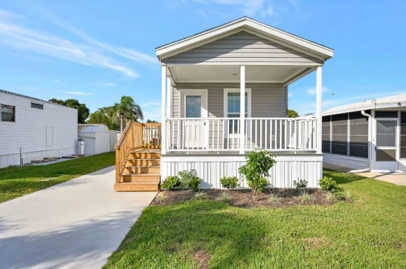 a manufactured home with a porch and a driveway