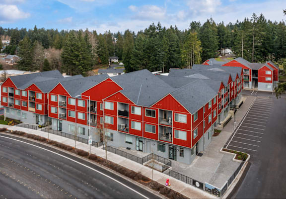 A large red building with a parking lot in front.