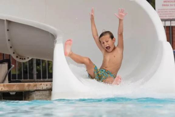 A child slides down a water slide.