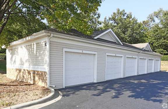A white garage with a black roof and four doors.