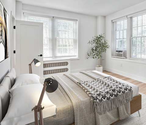 a bedroom with a bed and two windows