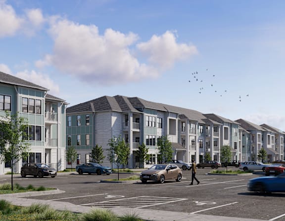 A row of modern townhouses with cars parked in front.