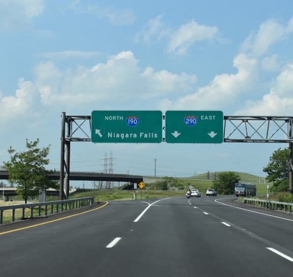 a highway with a green overhead sign with directions to napa falls and mcg