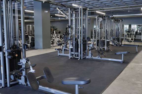A gym with a variety of equipment including weights and benches.at Converge KC Uptown, Missouri