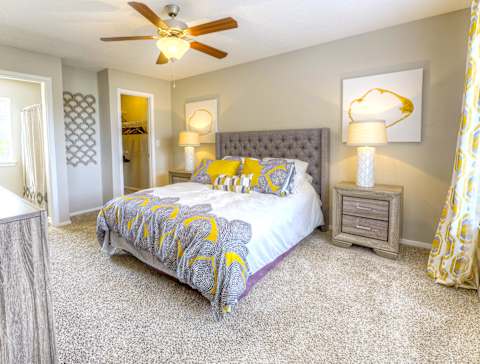 A bedroom with a bed, nightstand, and a ceiling fan. at North Creek, Southaven, Mississippi