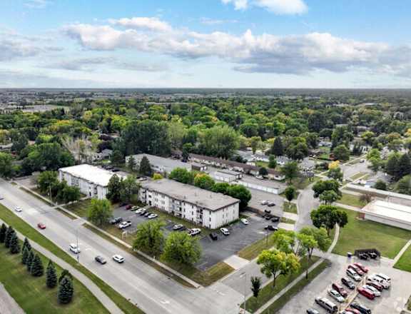 an aerial view of a parking lot and apartment buildings