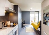 Thumbnail 1 of 8 - a bedroom with a bed and a desk in a room