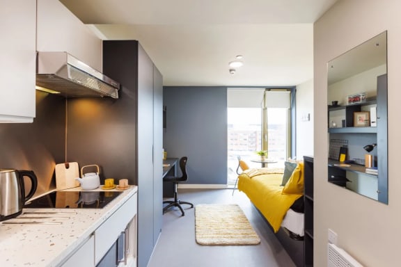 a bedroom with a bed and a desk in a room
