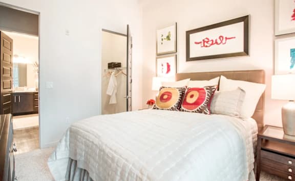 A bedroom with a large bed and a mirror on the wall.