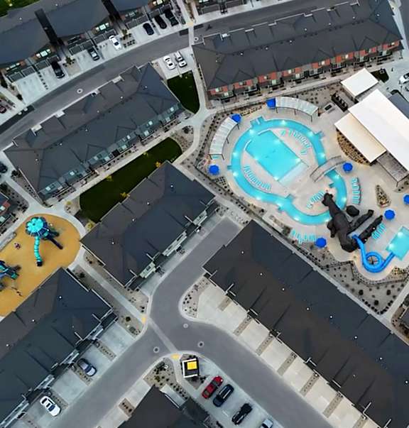A bird's eye view of a resort with a large pool and a water slide.