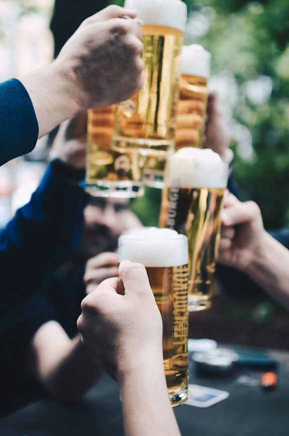 A group of people toasting with beer mugs.at Slate Yard Apartments, Salford, M3 5EX