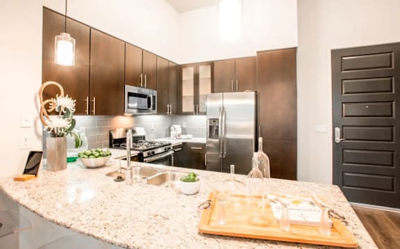 A kitchen with a granite countertop and stainless steel appliances.