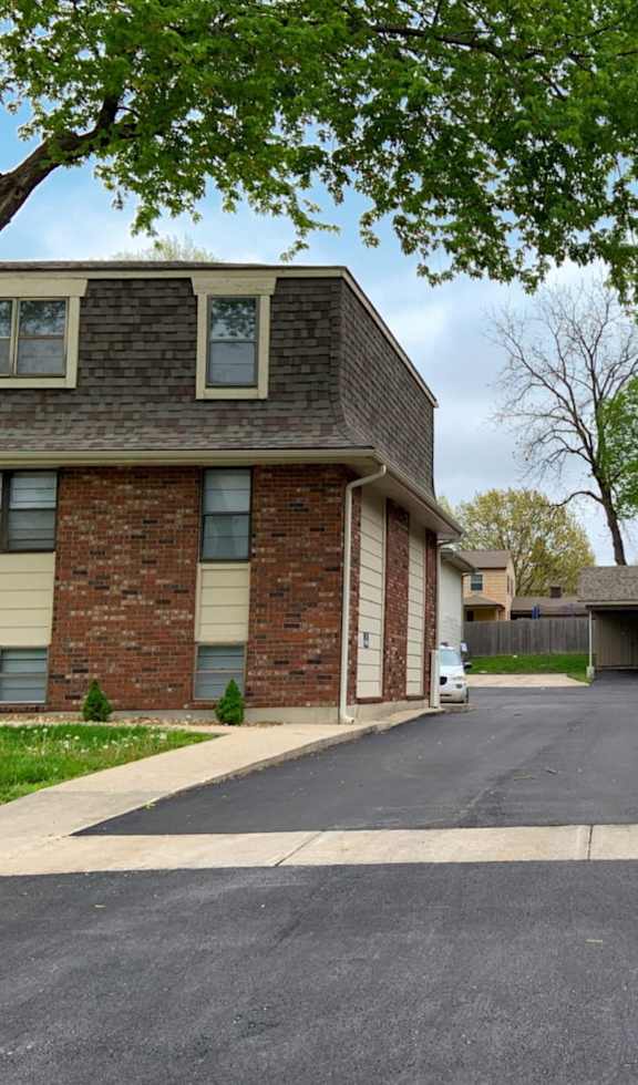 Brick apartment building with a tree in front.
