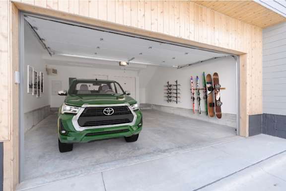 A green Toyota SUV is parked in a garage.