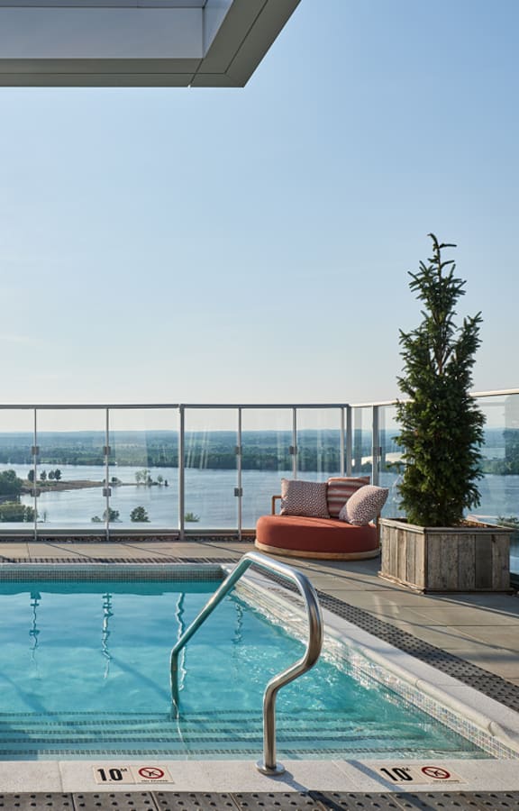 A sunny day at the pool with a view of the water.