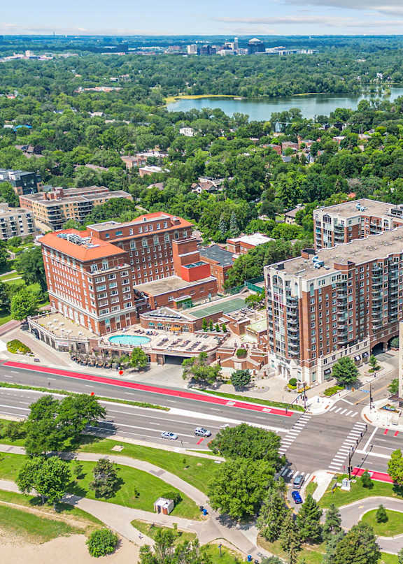 A tennis court is surrounded by apartment buildings.