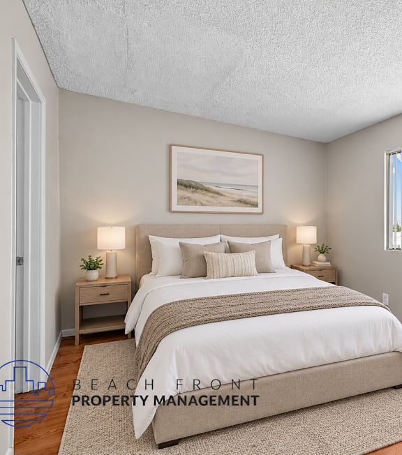 A bedroom with a large bed and a view of the beach through the window.