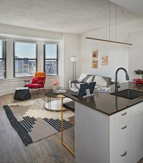a kitchen with white cabinets and a black counter top