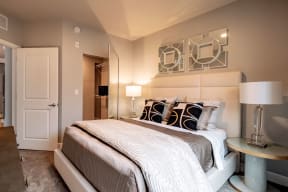 A bedroom with a king-size bed, closet, and nightstands at Gatsby Apartments. 