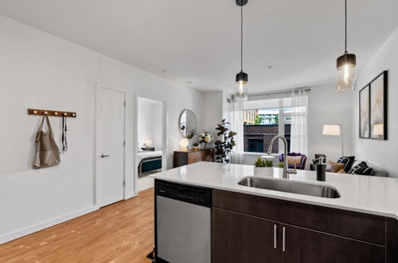 A modern kitchen with a wooden floor and white walls at The Parker Apartments in OR 97209