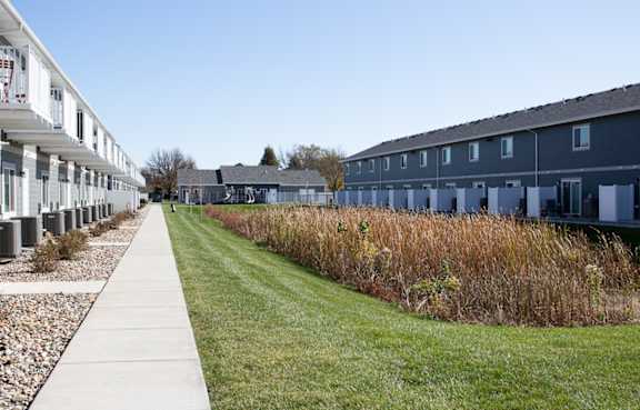 A long row of houses with a sidewalk in front.