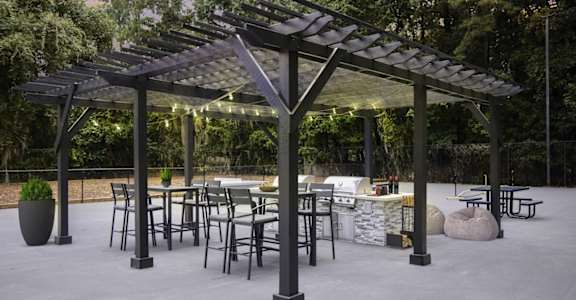 a patio with tables and chairs and a pergola