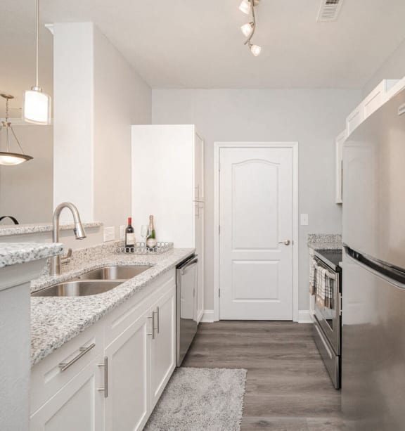 a kitchen with stainless steel appliances and white cabinets
