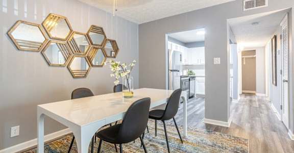 a dining room with a white table and black chairs at Station JTown, Louisville, KY, 40299