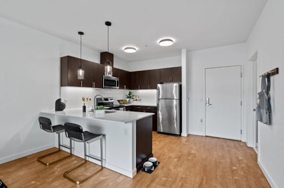 A modern kitchen with a white island and stainless steel appliances at The Parker Apartments in Portland, Oregon 97209