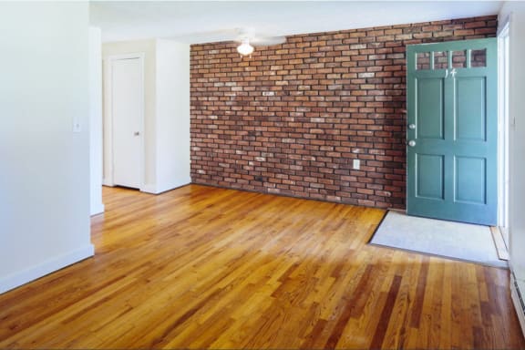 an empty living room with a sliding glass door and wood floors