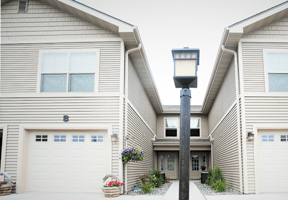 A street lamp stands between two houses with garages.