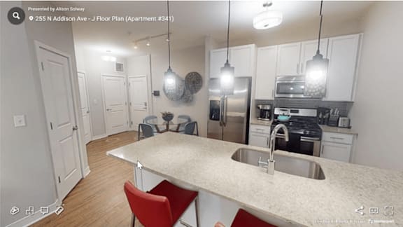 A kitchen with a white countertop and red chairs.