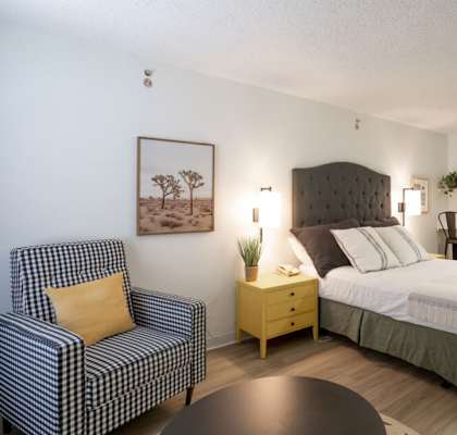 a bedroom with a bed and a chair and a table  at Waterford Studios, Texas