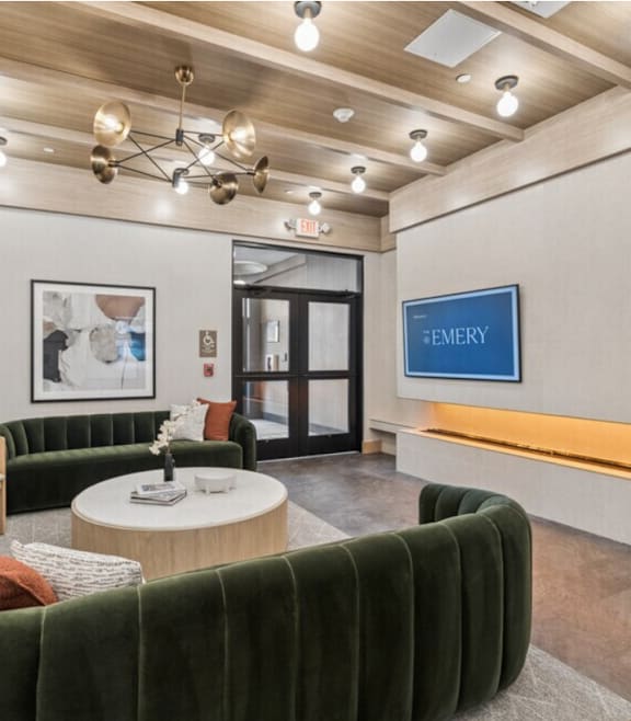 A modern waiting room with a green velvet sofa and a coffee table.