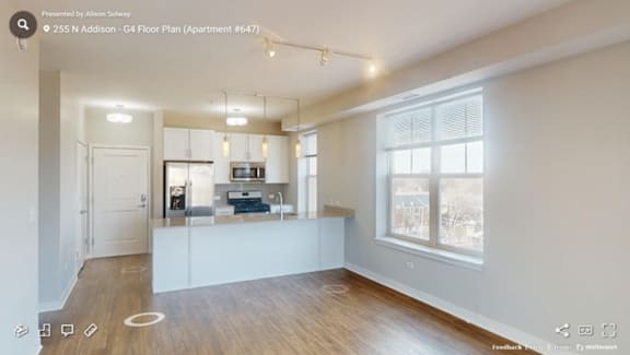 A spacious living room with a kitchenette and a large window.