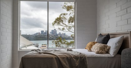 a bedroom with a bed and a window with a view of the city